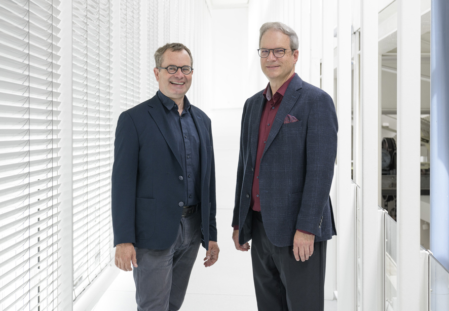 Im Bild stehend un einem hellen Flur die neue Doppelspitze des TECHNOSEUM , Prof. Dr. Andreas Gundelwein links und Dr. Jens Bortloff rechts im Bild.